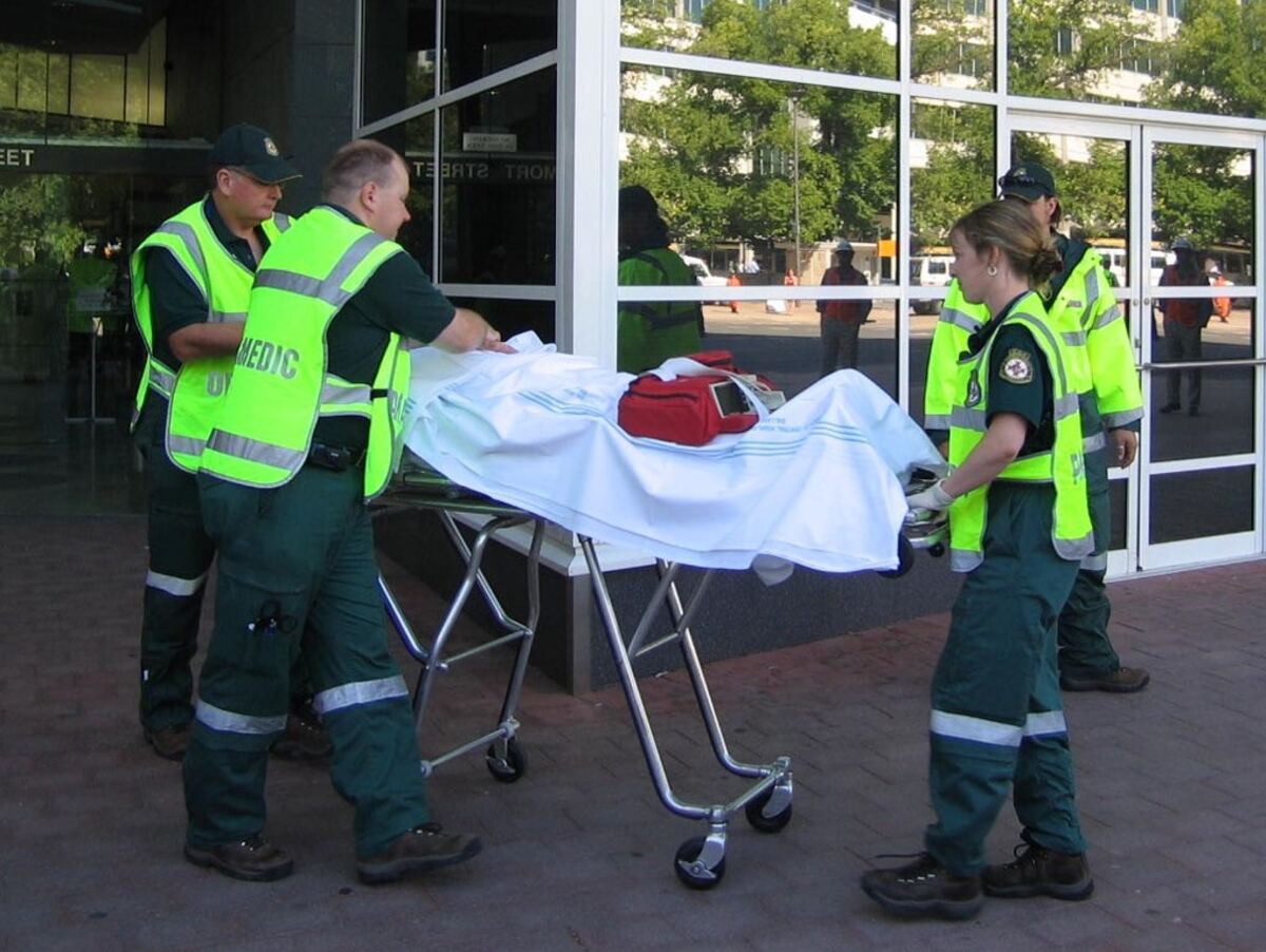 Paramedics shifting patient on stretcher in Noida